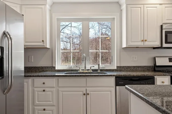 a kitchen with granite countertop white cabinets and a stainless steel appliances