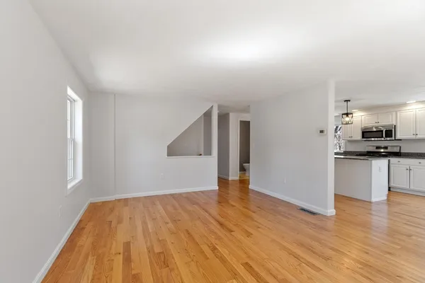 a view of kitchen with refrigerator and wooden floor