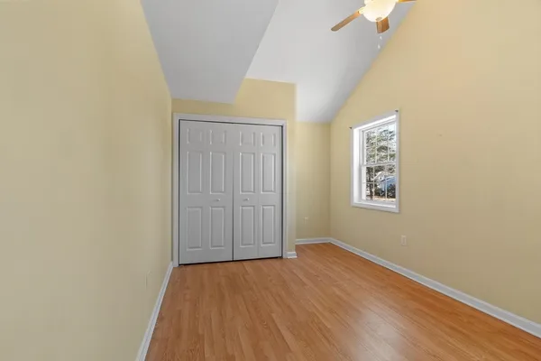 an empty room with wooden floor and windows