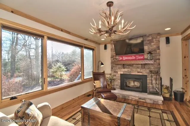 a living room with furniture a fireplace and a floor to ceiling window