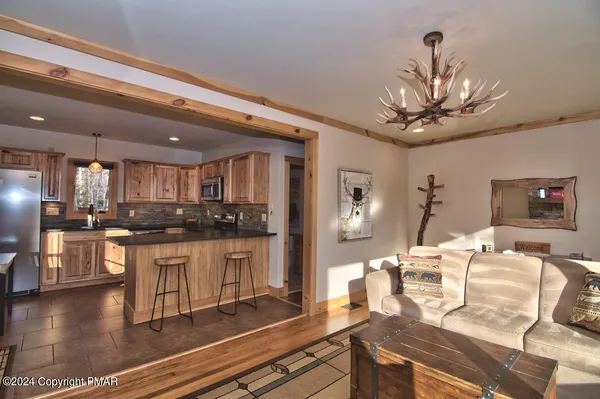 a living room with kitchen island furniture and a chandelier
