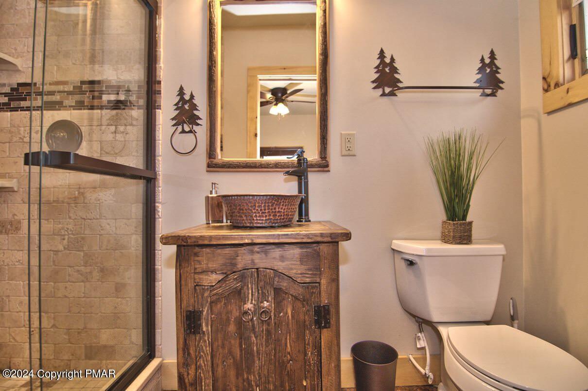 5187 Woodland Avenue Pocono Pines, PA 18350 - Photo 25 of 40 a bathroom with a toilet a sink and mirror