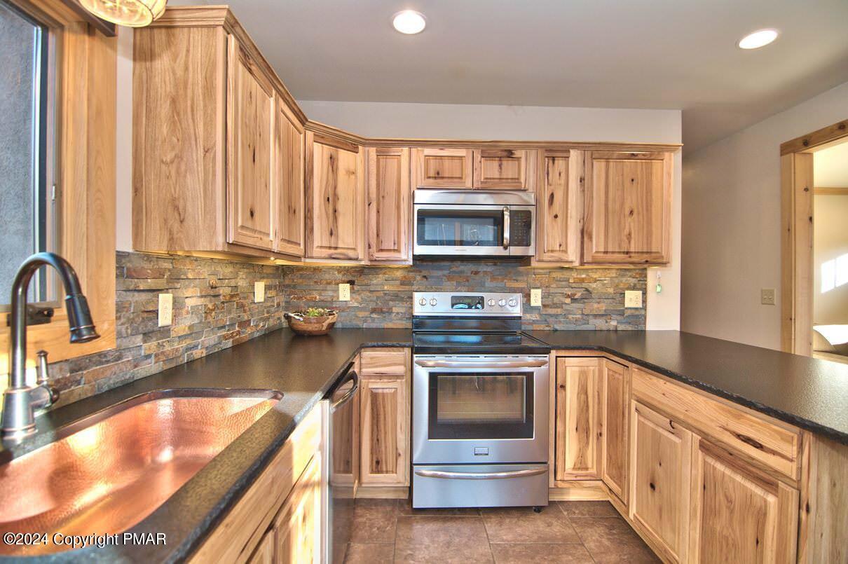 5187 Woodland Avenue Pocono Pines, PA 18350 - Photo 28 of 40 a kitchen with a stove a sink and a microwave