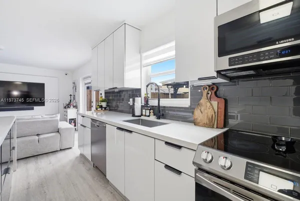 a kitchen with a stove and a white wooden cabinets