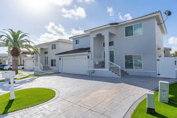 a view of a house with backyard and sitting area