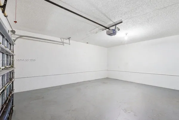 an empty room with projector and white walls