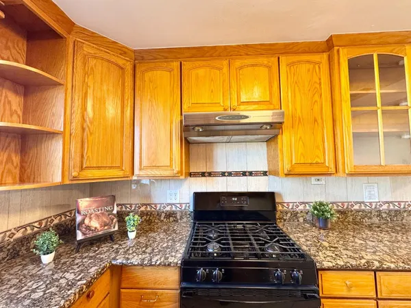 a kitchen with granite countertop a stove and a sink