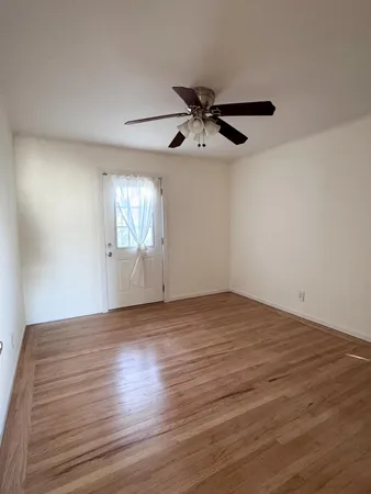 a view of empty room with wooden floor
