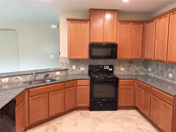 a kitchen with stainless steel appliances granite countertop a stove sink and cabinets