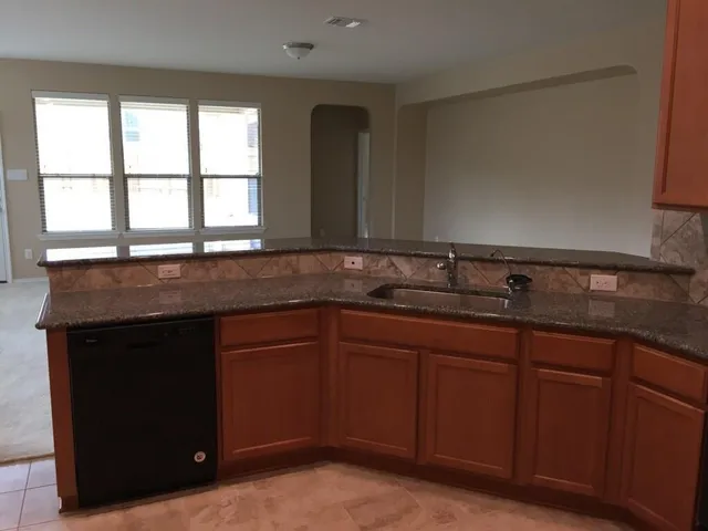 a kitchen with granite countertop a sink and a window