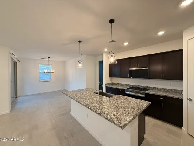 a kitchen with kitchen island granite countertop a stove and a sink