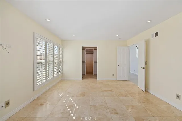 an empty room with windows and closet