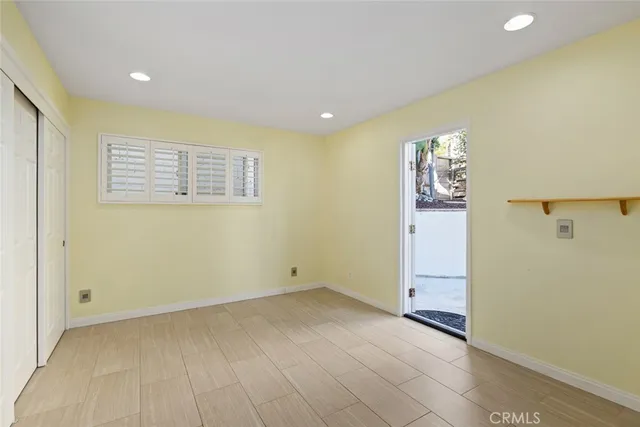 a view of empty room with wooden floor and windows