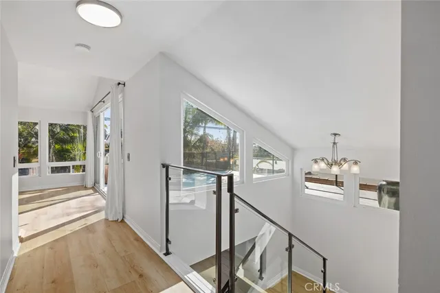 a view of a hallway with windows and chandelier