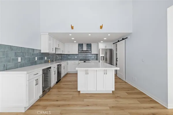 a large kitchen with stainless steel appliances granite countertop a sink and cabinets