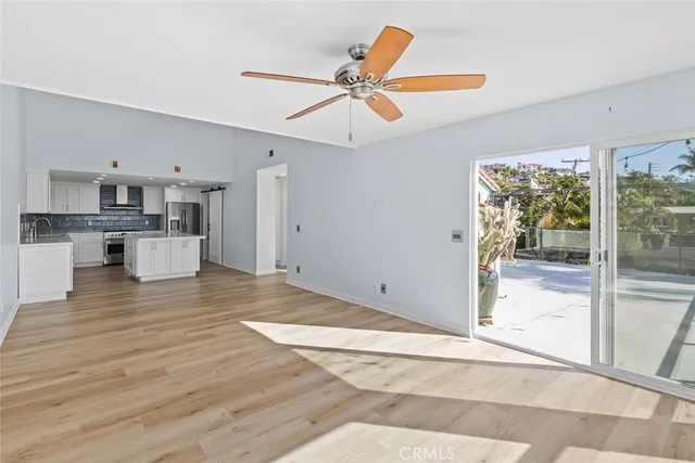 a view of a kitchen with wooden floor and a ceiling fan