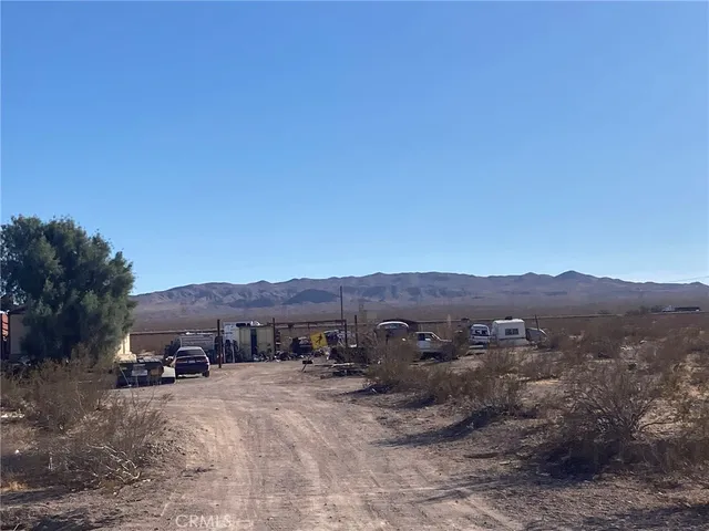a view of a lush green field and mountains