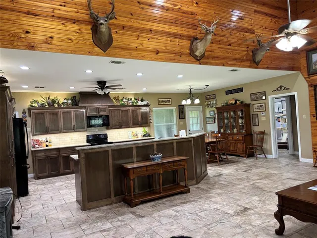 a kitchen with stainless steel appliances kitchen island granite countertop a sink and a stove