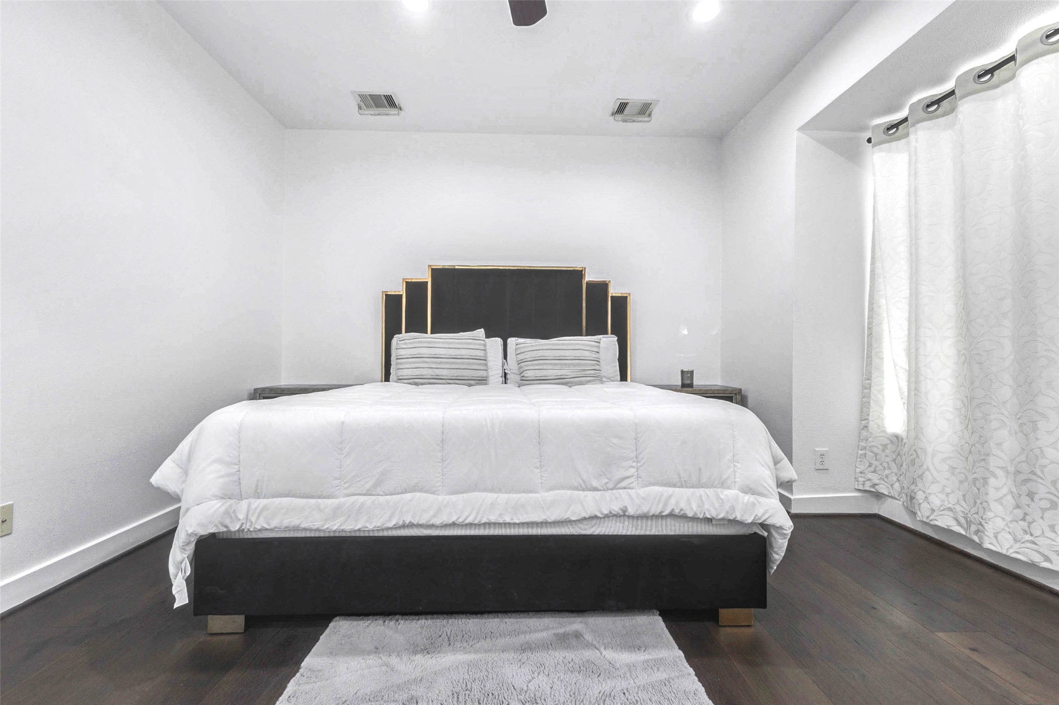 5715 Larkin Street, Unit D Houston, TX 77007 - Photo 14 of 38 Generously sized primary suite. Dark hardwood floors add warmth, while recessed lighting and ceiling fan enhance comfort. The room offers ample wall space for additional furnishings and décor.