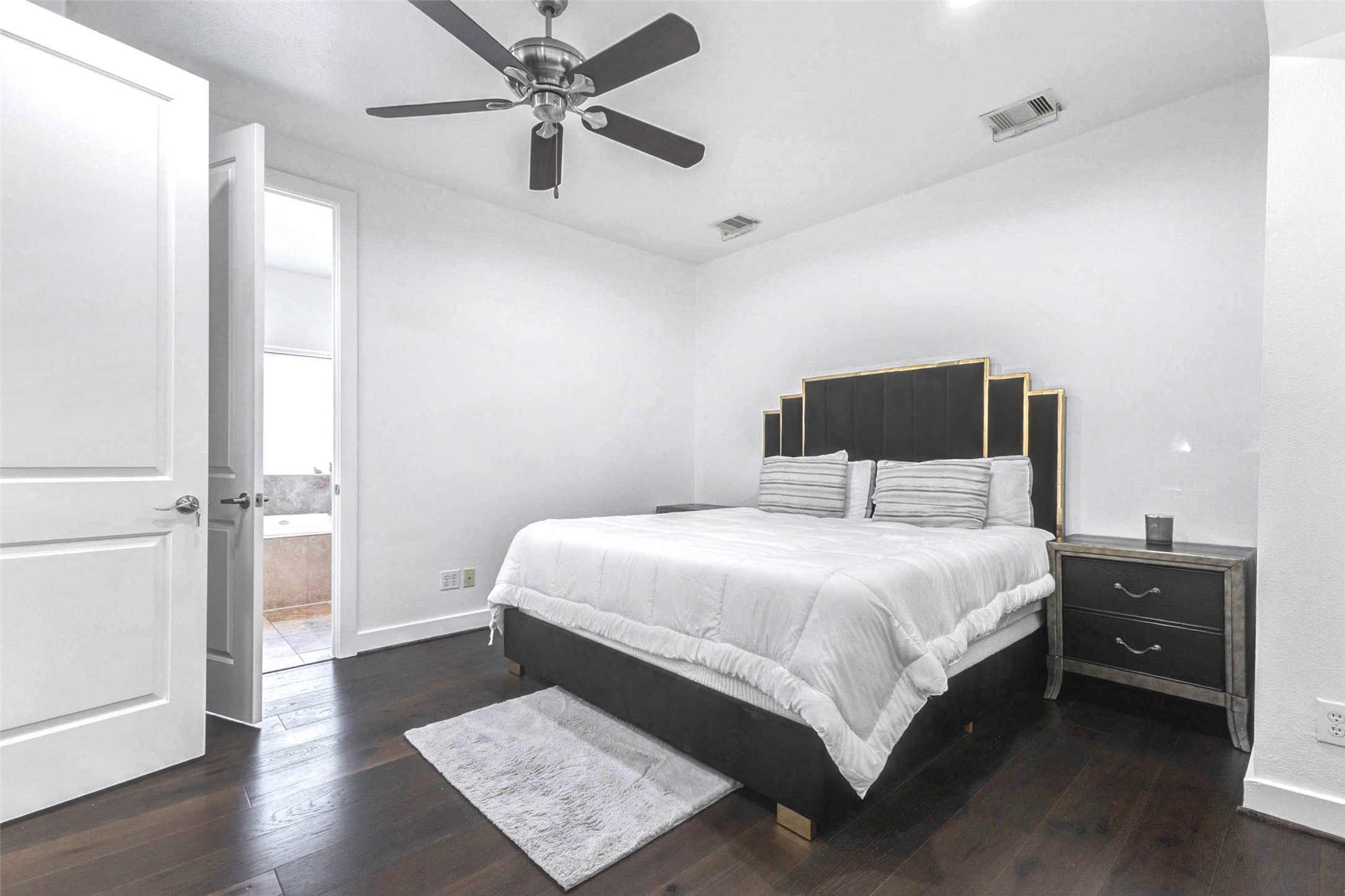 5715 Larkin Street, Unit D Houston, TX 77007 - Photo 15 of 38 Alternate view of the primary suite showcasing expansive layout and direct access to the en-suite bath. Large windows dressed in soft curtains allow filtered daylight to brighten the room. Neutral tones and clean lines provide a serene atmosphere ideal for relaxation.