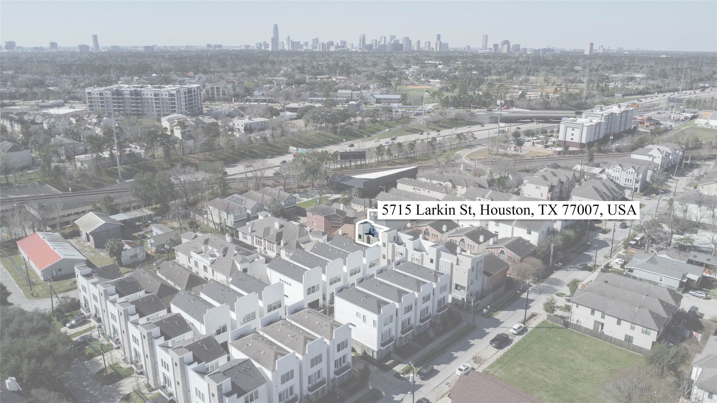 5715 Larkin Street, Unit D Houston, TX 77007 - Photo 31 of 38 Aerial perspective highlighting the home’s prime Cottage Grove location with Downtown Houston skyline visible in the distance. The property is clearly marked within the contemporary townhome community, illustrating proximity to major roadways, shopping, dining and entertainment.