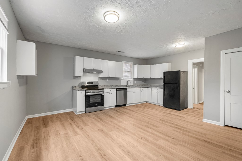 1301 20th Street Columbus, GA 31901 - Photo 12 of 16 a large kitchen with a refrigerator and a stove top oven