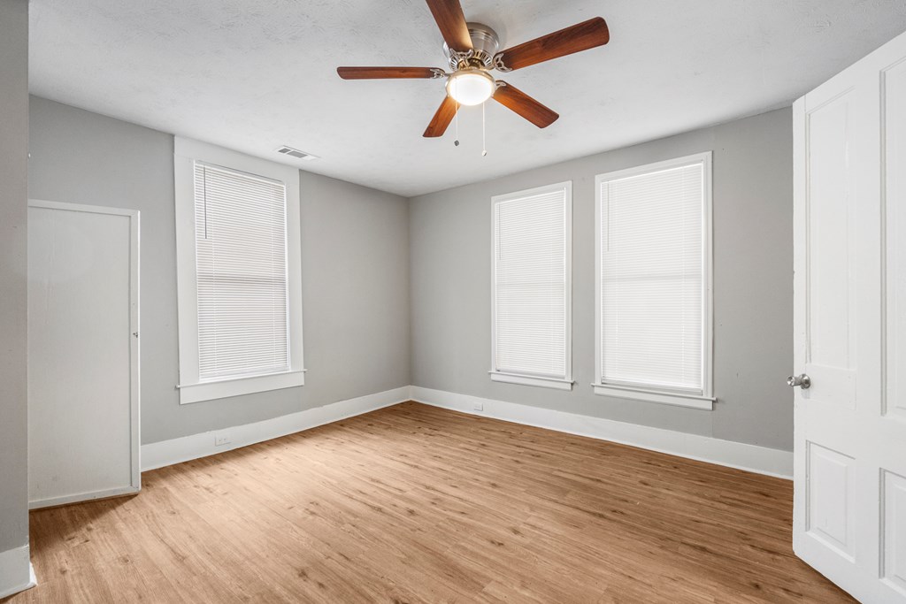 1301 20th Street Columbus, GA 31901 - Photo 3 of 16 an empty room with wooden floor ceiling fan and windows
