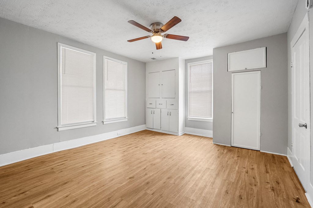 1301 20th Street Columbus, GA 31901 - Photo 4 of 16 an empty room with wooden floor and ceiling fan