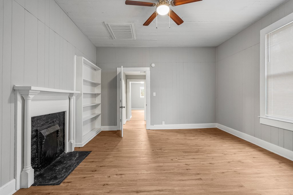 1301 20th Street Columbus, GA 31901 - Photo 7 of 16 an empty room with wooden floor fireplace and windows