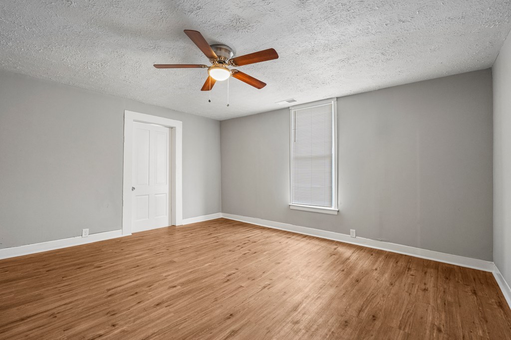 1301 20th Street Columbus, GA 31901 - Photo 10 of 16 a view of an empty room with wooden floor and a window