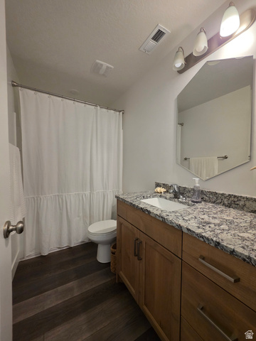 1237 West 3440 South Logan, UT 84321 - Photo 29 of 29 Bathroom featuring a wood-finish vanity with an integrated sink, stone countertop, and dark wood-finish flooring