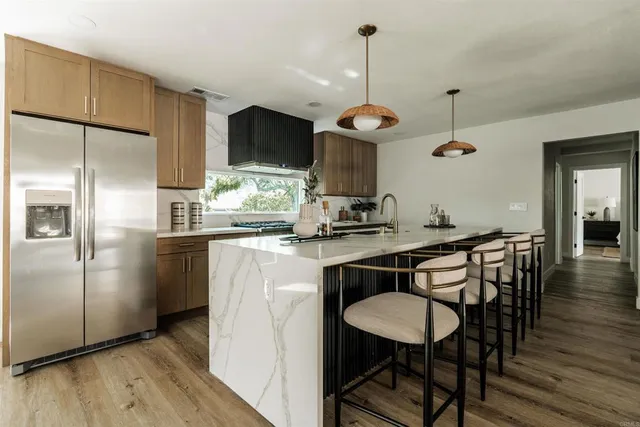 a kitchen with stainless steel appliances a table chairs refrigerator and microwave