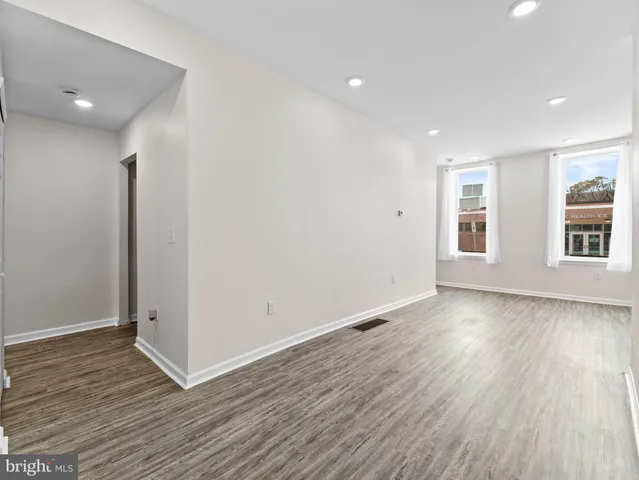 a view of a room with wooden floor and window