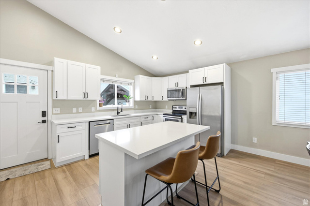 11859 Preamble Road Draper, UT 84020 - Photo 5 of 30 Open-concept kitchen featuring white cabinetry, stainless steel appliances, and a central island with a solid surface countertop