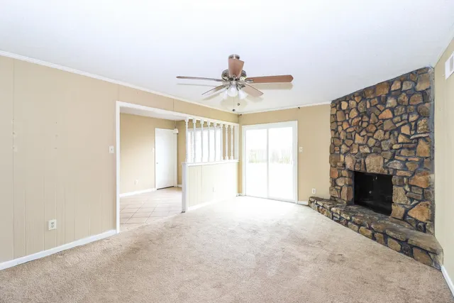 a view of an empty room with a fireplace and a window
