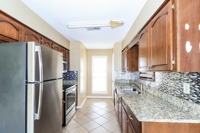 a kitchen with stainless steel appliances granite countertop a refrigerator and a stove