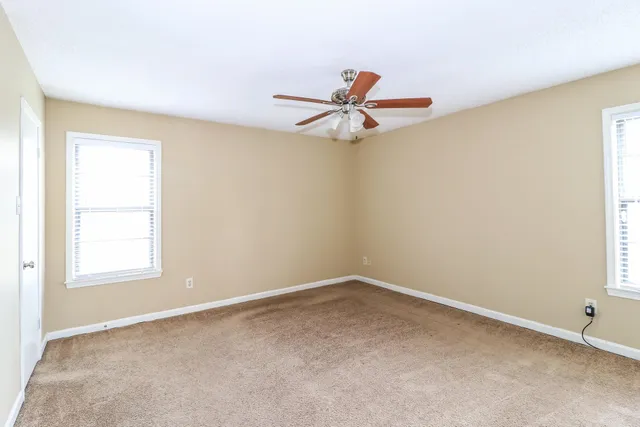 an empty room with a window and a ceiling fan