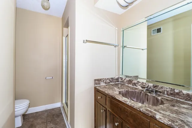 a bathroom with a granite countertop sink and a mirror