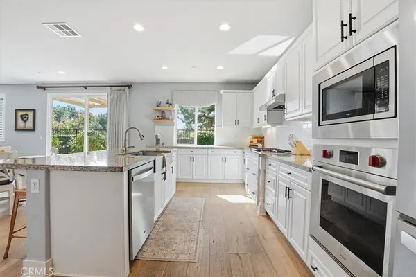 a kitchen with stainless steel appliances kitchen island granite countertop a stove and a sink