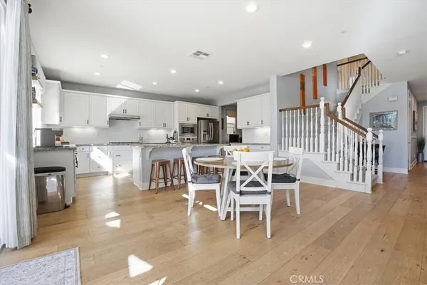 a dining area with stainless steel appliances kitchen island granite countertop a table and chairs