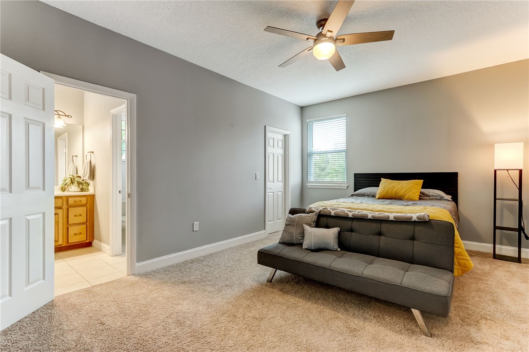 96266 Dowling Drive Yulee, FL 32097 - Photo 21 of 35 a spacious bedroom with a bed and a chandelier