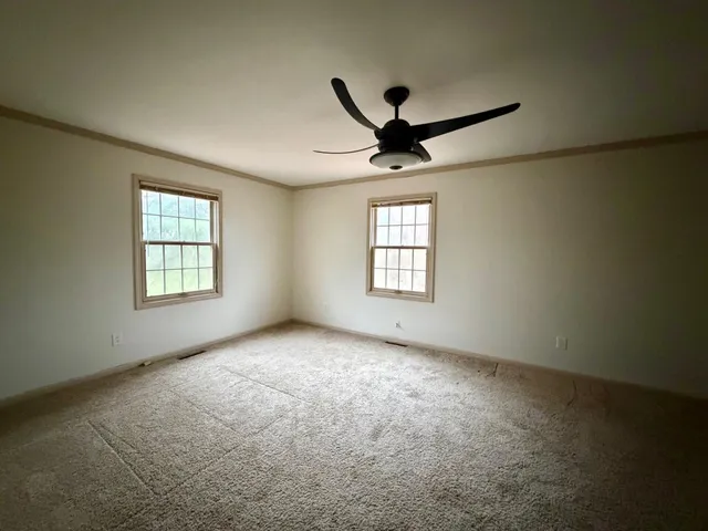 a view of a livingroom with a ceiling fan and window