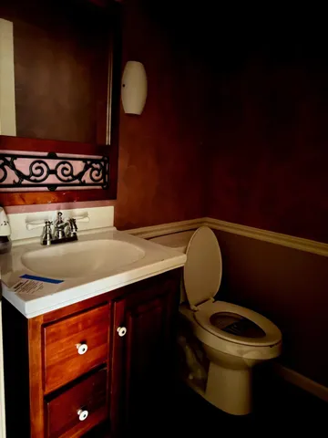 a bathroom with a toilet sink and mirror
