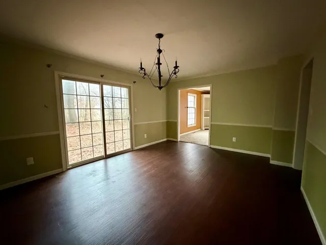 a view of a livingroom with wooden floor and a window