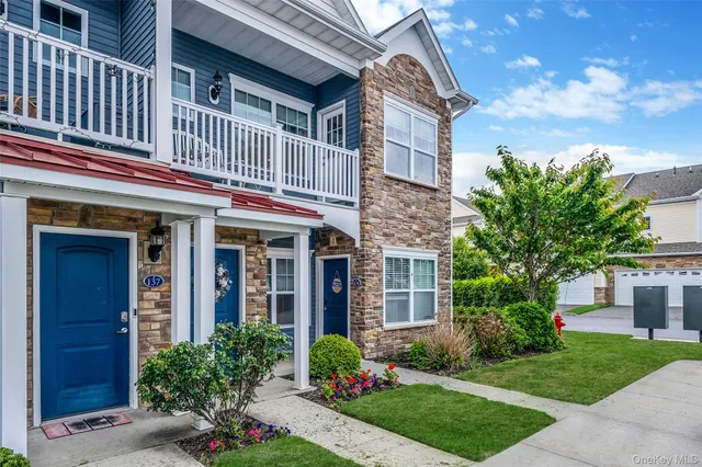 front view of a brick house with a yard