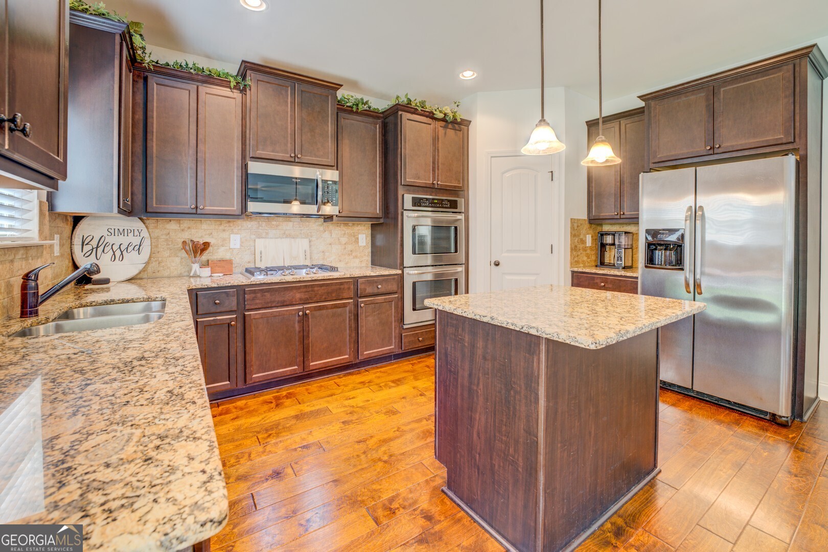 312 Relative Trail McDonough, GA 30253 - Photo 17 of 54 a kitchen with stainless steel appliances granite countertop a refrigerator a sink dishwasher a oven with wooden cabinets and floor