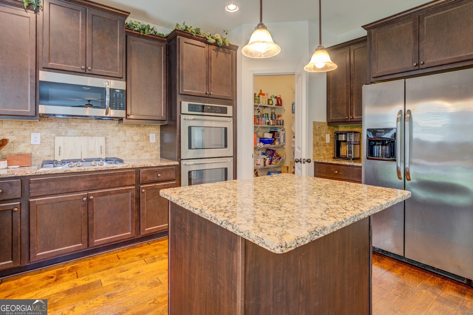 312 Relative Trail McDonough, GA 30253 - Photo 19 of 54 a kitchen with stainless steel appliances granite countertop a sink refrigerator and cabinets