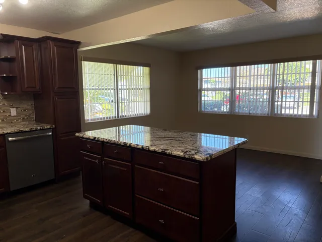 a kitchen with granite countertop wooden cabinets and a granite counter top