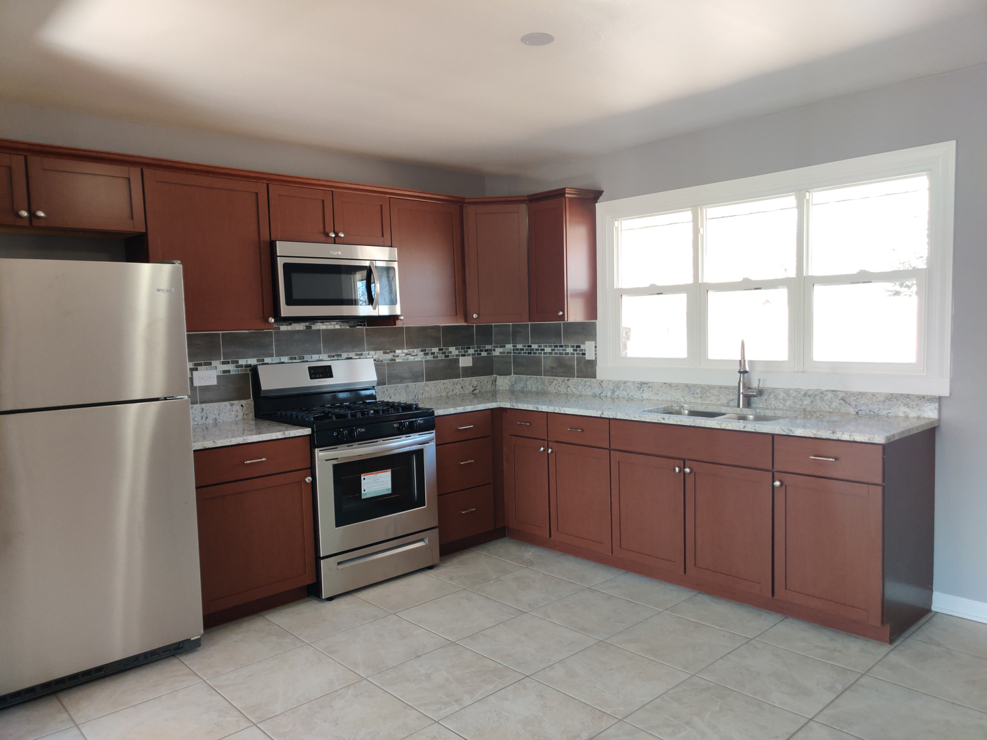 1101 Westminster Road Joliet, IL 60435 - Photo 3 of 17 a kitchen with granite countertop stainless steel appliances a refrigerator stove and microwave