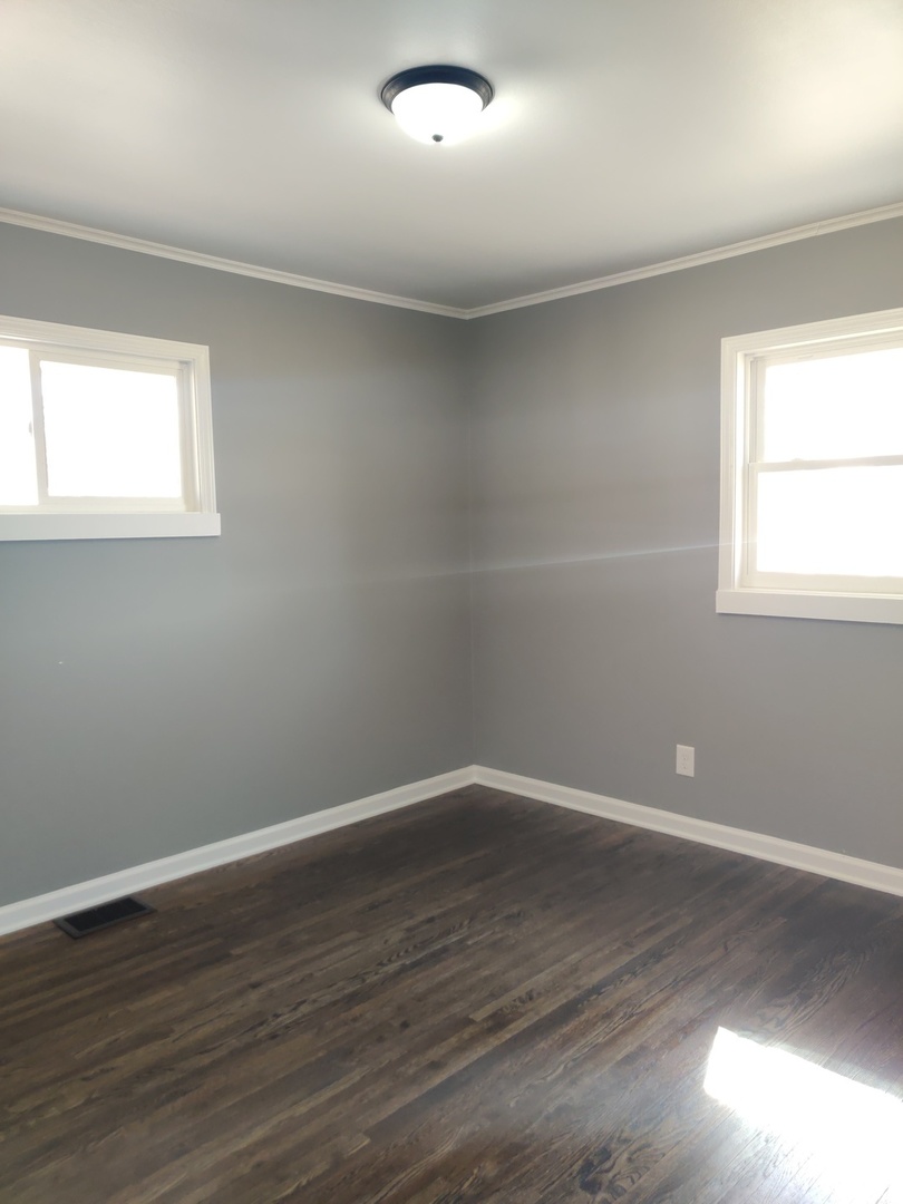 1101 Westminster Road Joliet, IL 60435 - Photo 4 of 17 a view of an empty room with wooden floor and a window